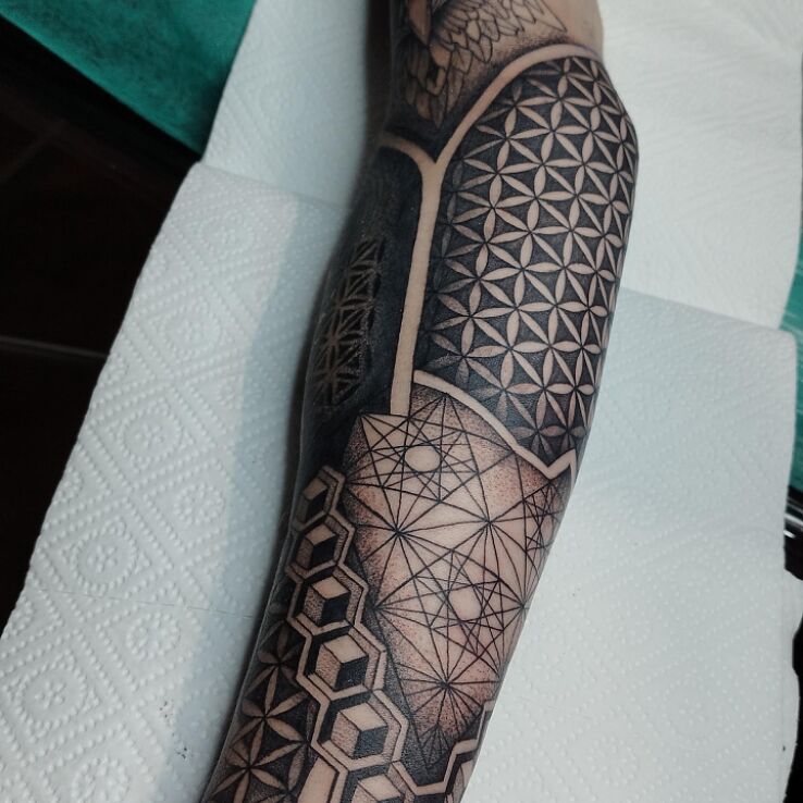 Tatuaż święta geometria w motywie czarno-szare i stylu blackwork / blackout na ręce