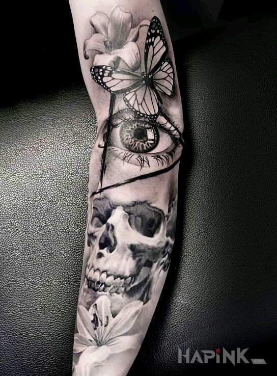 Tattoo Czaszka in flowers motif and realistic style on the bicep