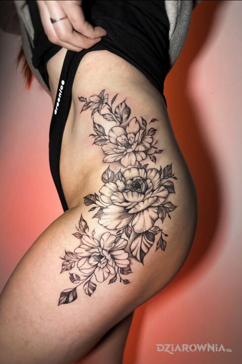 Tatuaż kwiaty na biodrze w motywie czarno-szare i stylu kontury / linework na pośladkach