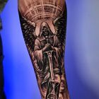 Tatuaż aniol śmierci z mieczem na przedramieniu na łokciu, motyw: wojna, styl: biały tusz