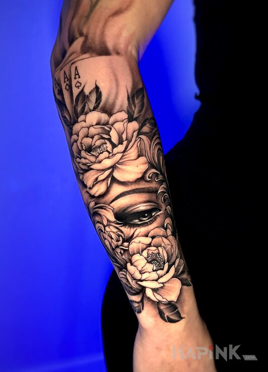 Tattoo Kwiaty i oko na przedramieniu in flowers motif and realistic style On the arm