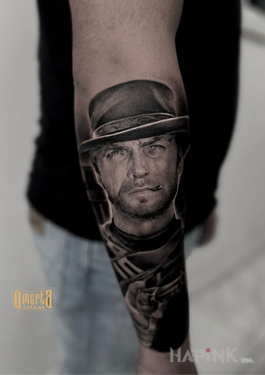Tattoo Clint Eastwood portret in black and gray motif and realistic style On the arm