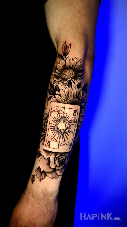 Tattoo Karta do grania i kwiaty in black and gray motif and realistic style on the forearm
