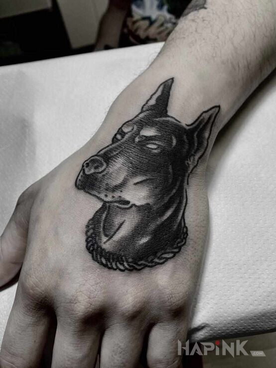 Tattoo Doberman in black and gray motif and graphic / illustrative style On the arm