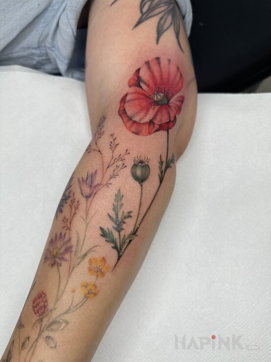 Tattoo Kwiaty dla Dominiki in colorful motif and realistic style on the forearm