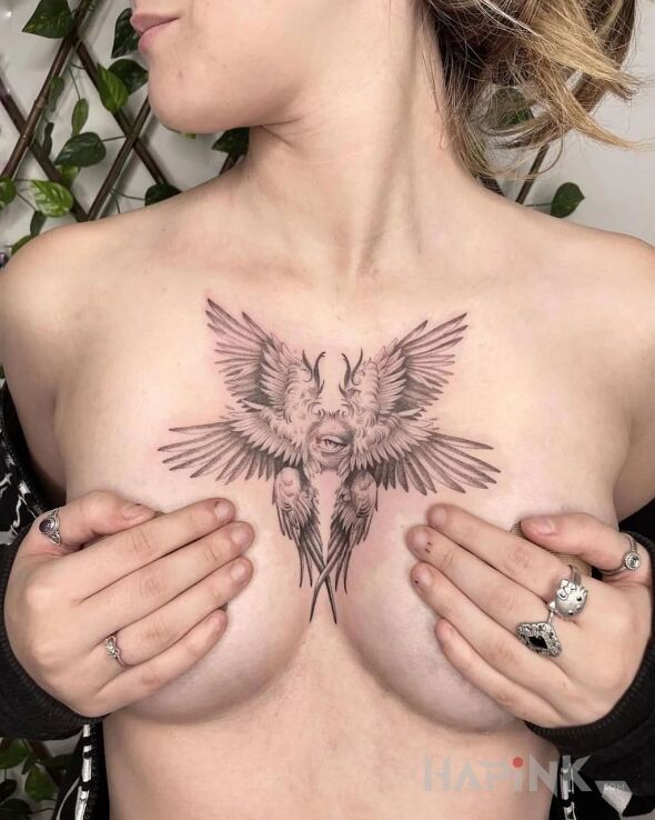 Tattoo Skrzydlata istota in wings motif and surrealistic style on the chest