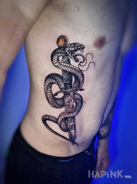 Tattoo Wąż z sztyletem na żebrach in dark motif and realistic style on the ribs