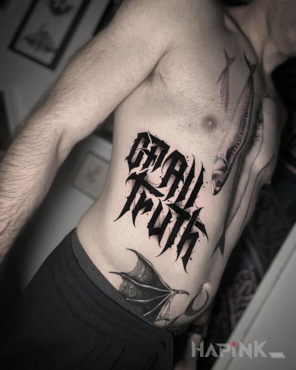 Tattoo Of all truth. in black and gray motif and blackwork / blackout style on the stomach