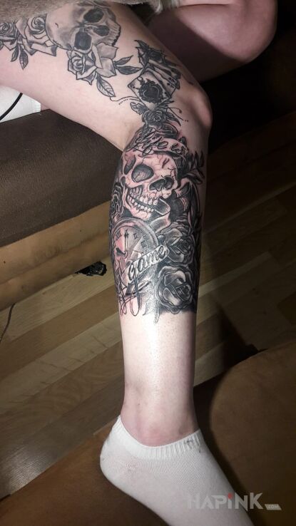 Tattoo Czaszka i zegar in skulls motif on the leg