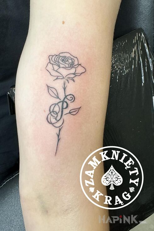 Tattoo Literka in flowers motif and contour / linework style On the arm