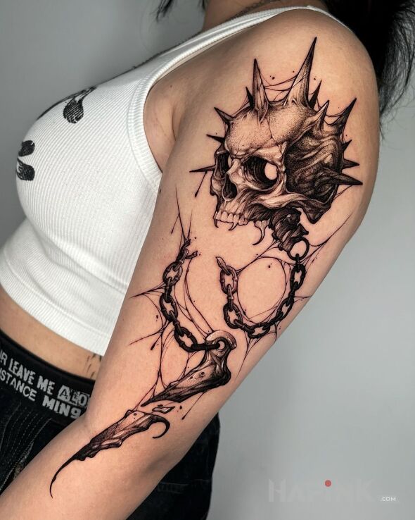 Tattoo Czacha z kolcami in dark motif and realistic style on the upper arm