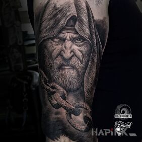 Tattoo Some old man with a chain on the upper arm motif: black and gray style: realistic