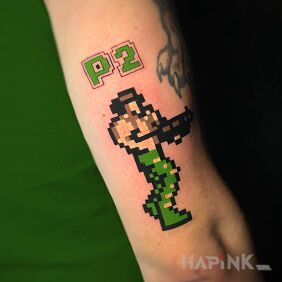 Tattoo Pixel Contra tattoo v2 on the upper arm motif: colorful style: newschool