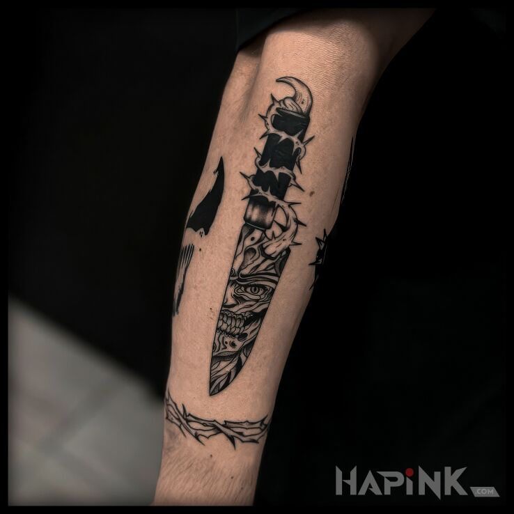 Tattoo Nawiedzone ostrze in dark motif and oldschool style On the arm
