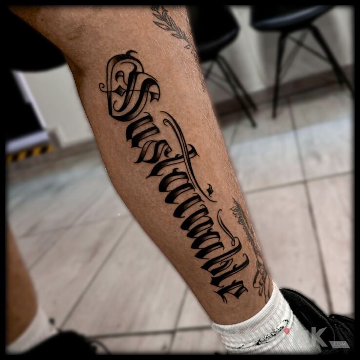 Tattoo Sustainable in criminal lettering motif and calligraphy style on the calf