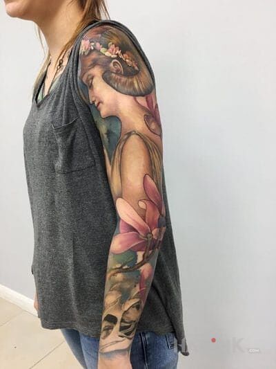 Tattoo Kobieta z rogami in flowers motif on the forearm