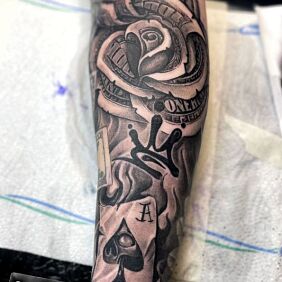 Tatuaż TATUAŻ NA PRZEDRAMIENIU DOLARY PIENIĄDZE RÓŻA KARTY na ręce motyw: kasyno styl: realistyczne