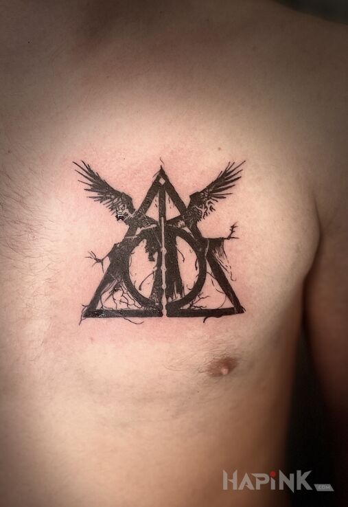 Tattoo HARRY POTTER DEATHLY HALLOWS in black and gray motif and blackwork / blackout style on the chest