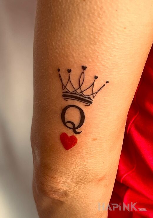 Tattoo CROWN WITH QUEEN OF SPADES in colorful motif and minimalistic style On the arm
