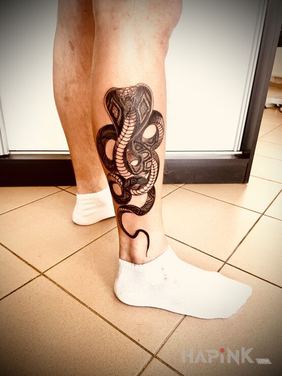 Tattoo KING COBRA in black and gray motif and graphic / illustrative style on the calf