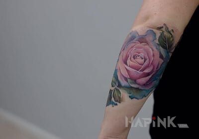 Tattoo Zarąbista róża in flowers motif and realistic style on the forearm