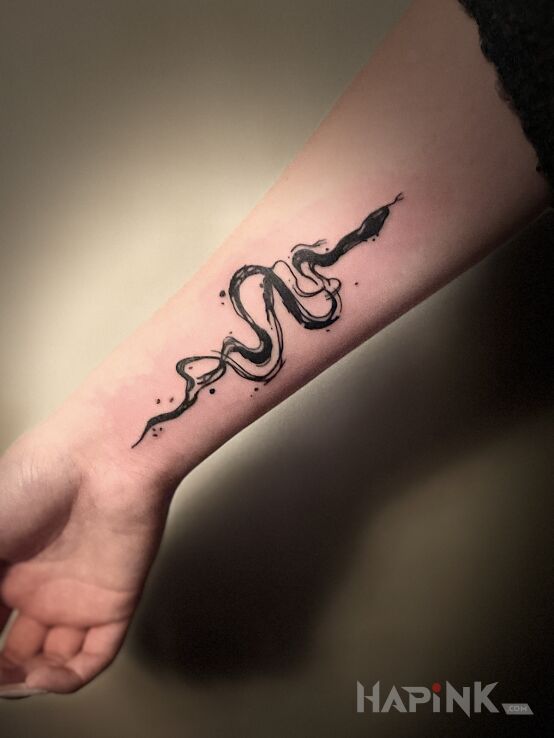 Tattoo GRAPHIC SNAKE in black and gray motif and blackwork / blackout style on the forearm
