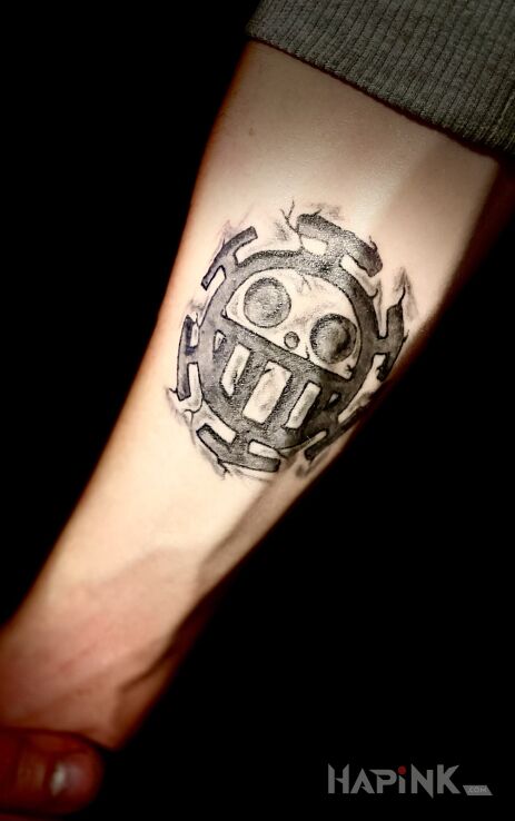Tattoo ONE PIECE STAMP in black and gray motif and graphic / illustrative style On the arm