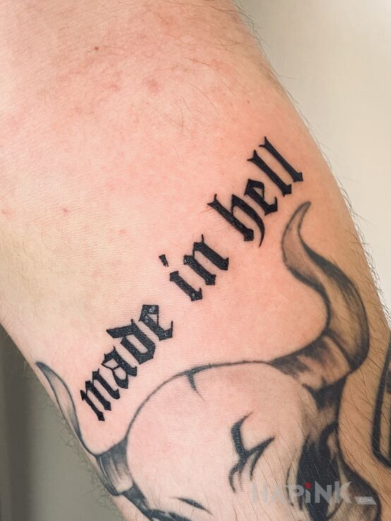 Tattoo Made in hell in lettering motif and calligraphy style on the forearm