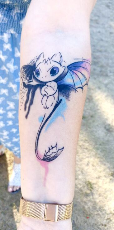 Tattoo Toothless from How to Train Your Dragon in fantasy motif and graphic / illustrative style on the forearm