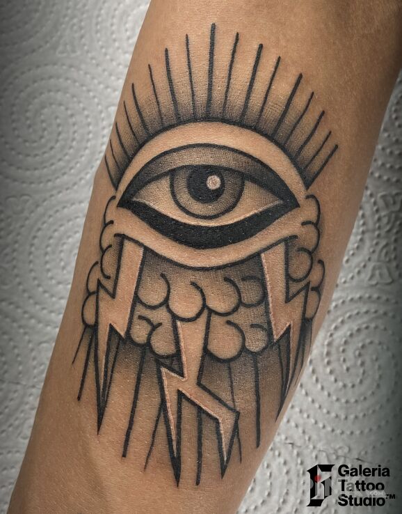 Tattoo Oldschool oko chmury pioruny in black and gray motif and contour / linework style On the arm