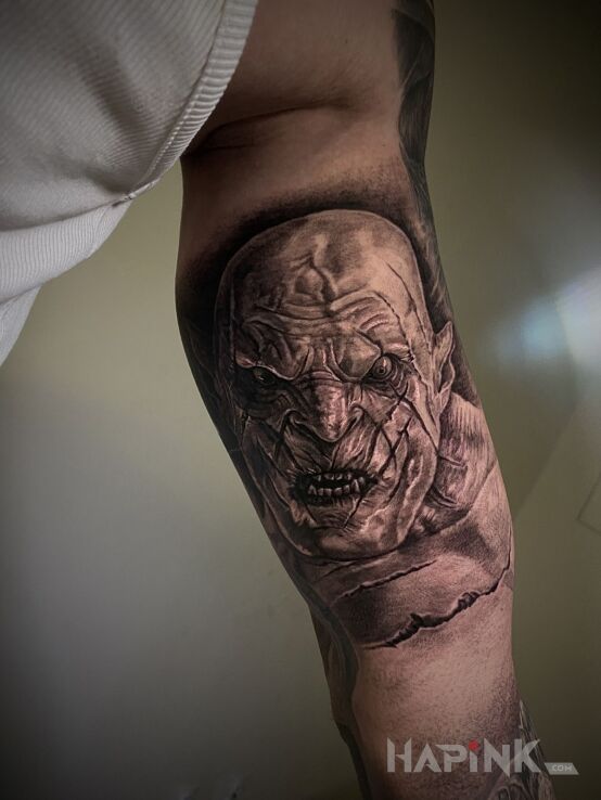 Tattoo Azog LOTR in faces motif and realistic style on the bicep