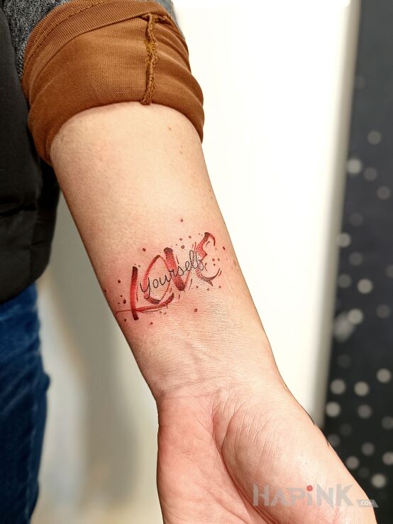 Tattoo Miłość in Love motif and graphic / illustrative style on the forearm