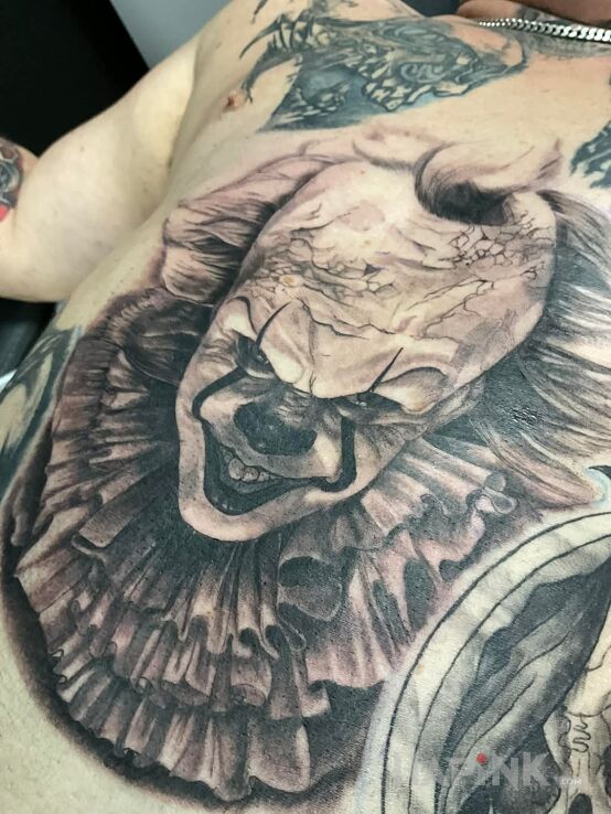 Tattoo Pennywise in black and gray motif and realistic style on the stomach