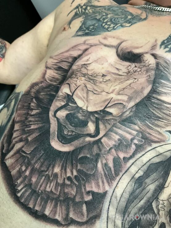 Tatuaż pennywise w motywie mroczne i stylu realistyczne na brzuchu