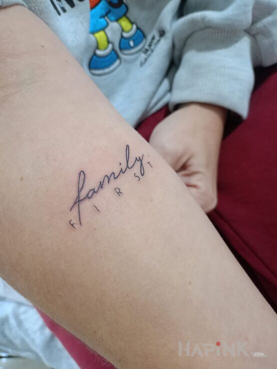 Tattoo Rodzina zawsze pierwsza in lettering motif and minimalistic style on the forearm