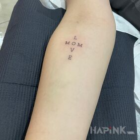 Tattoo Love Mom on the forearm motif: lettering style: calligraphy