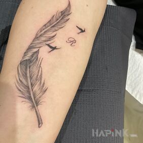 Tattoo Feather on the forearm motif: black and gray style: realistic