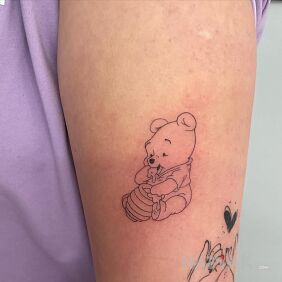 Tattoo Winnie the Pooh on the upper arm style: minimalistic