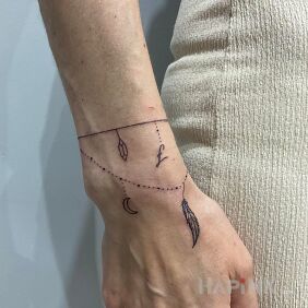 Tattoo Feather bracelet on the wrist style: minimalistic
