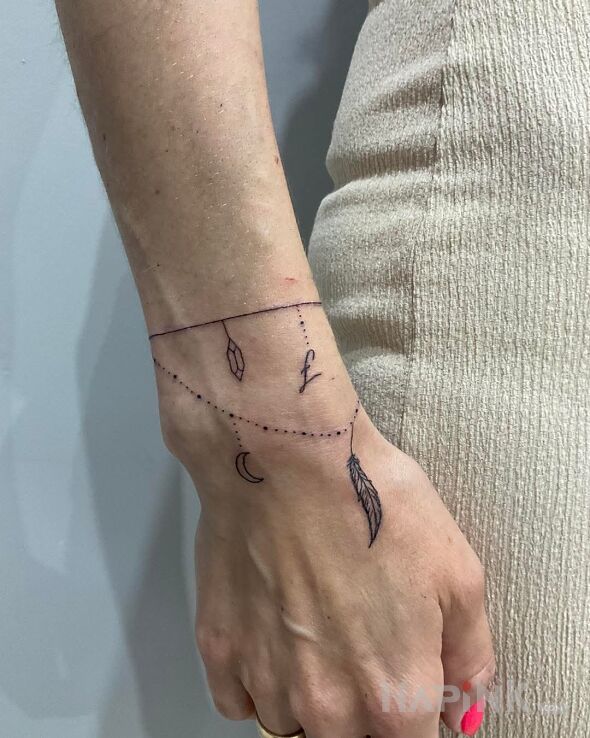 Tattoo Bransoletka piórko in black and gray motif and contour / linework style on the hand
