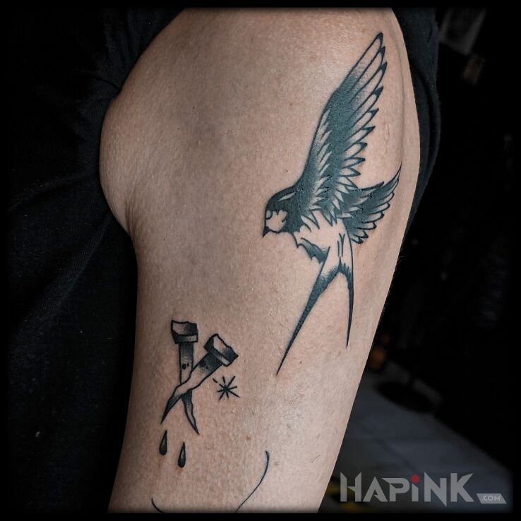 Tattoo Jaskółka i gwoździe in black and gray motif and oldschool style On the arm