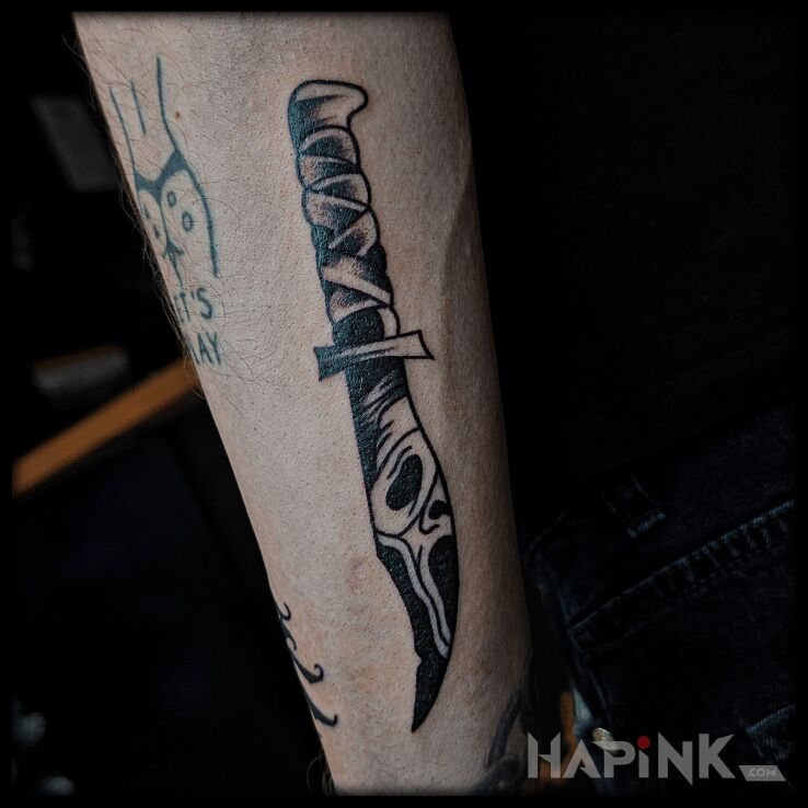 Tattoo Nóż z filmu Krzyk in black and gray motif and oldschool style On the arm
