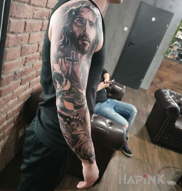 Tattoo Jezus i Anioł stróż in religious motif and realistic style On the arm