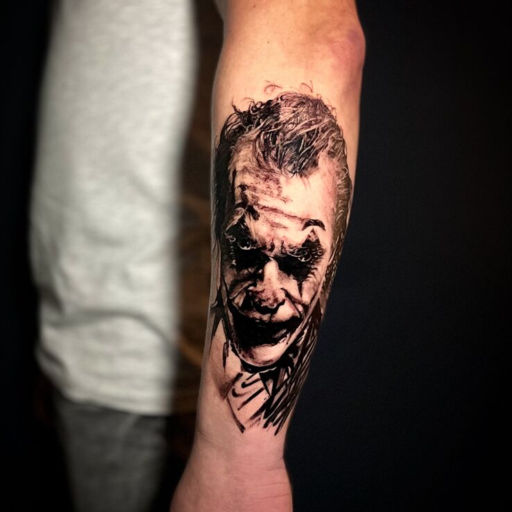 Tatuaż joker w motywie twarze i stylu realistyczne na przedramieniu