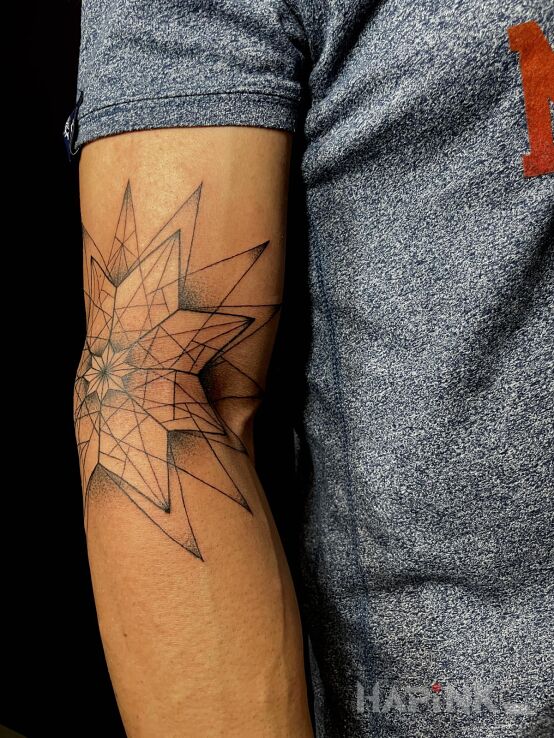 Tattoo Gwiazda w geometrii in black and gray motif and dotwork style On the arm
