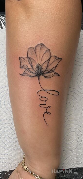 Tattoo Kwiat z napisem LOVE in flowers motif and graphic / illustrative style On the arm