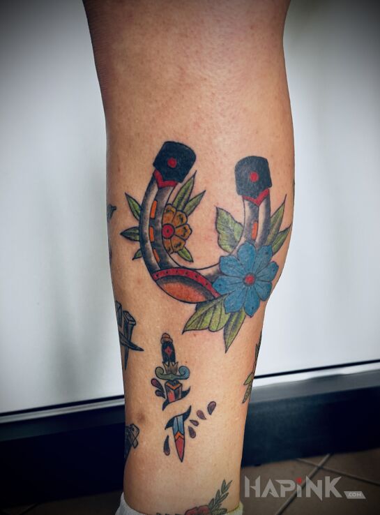Tattoo Colorful Horseshoe for Luck in colorful motif and oldschool style on the leg