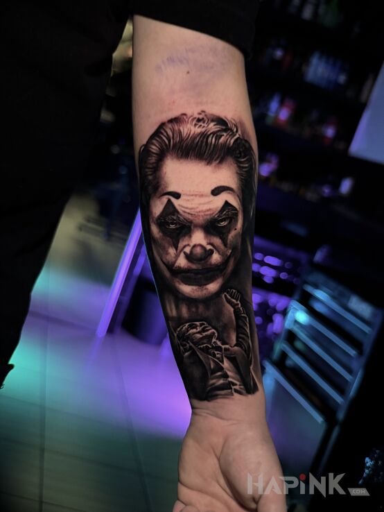 Tattoo Joker in characters motif and realistic style on the forearm