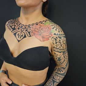 Tattoo Female Polynesian sleeve and chest piece On the arm motif: colorful style: Polynesian