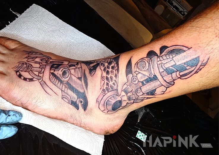 Tattoo Biomechanika in black and gray motif and biomechanics style on the foot